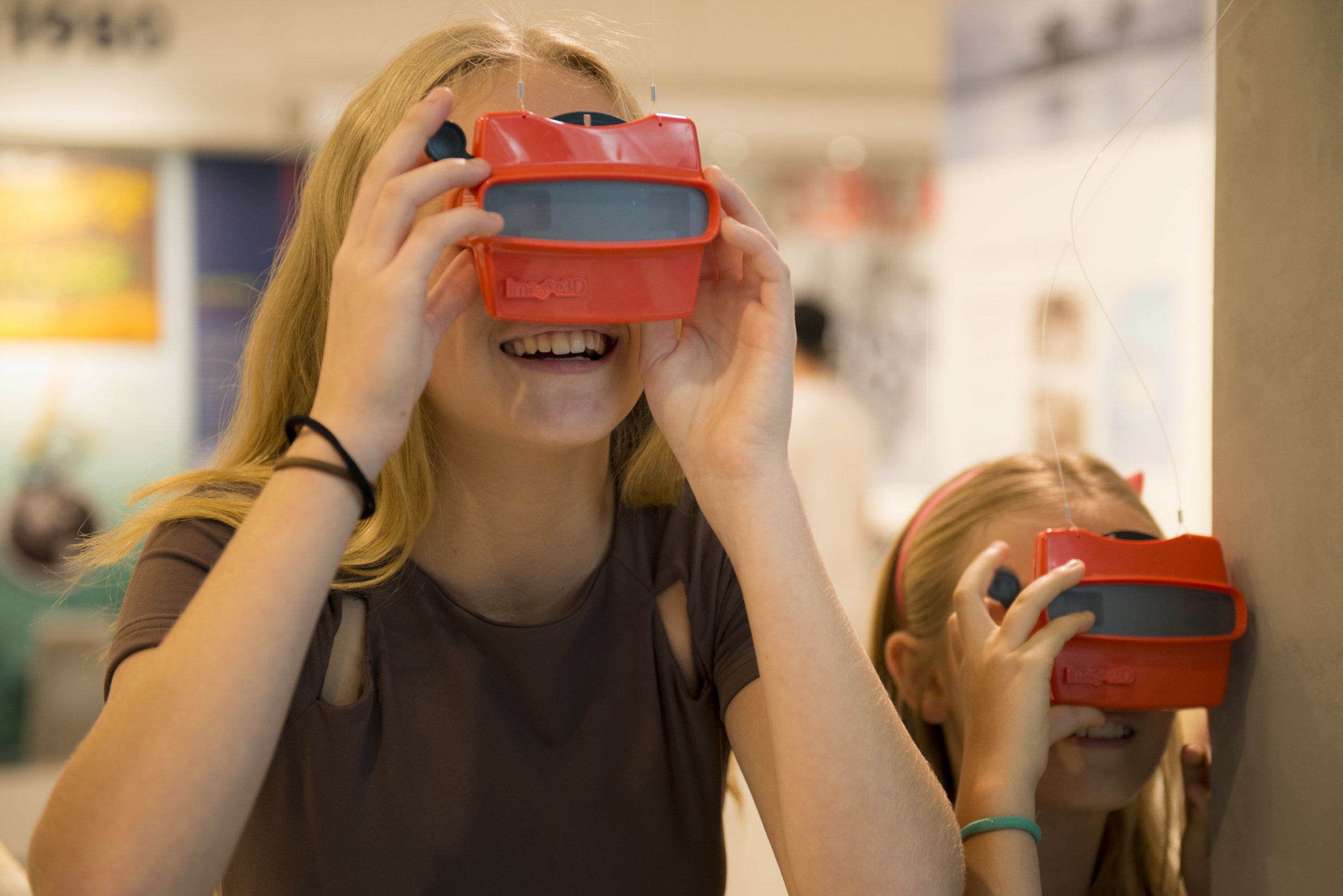 Two museum visitors looking through an Image3D