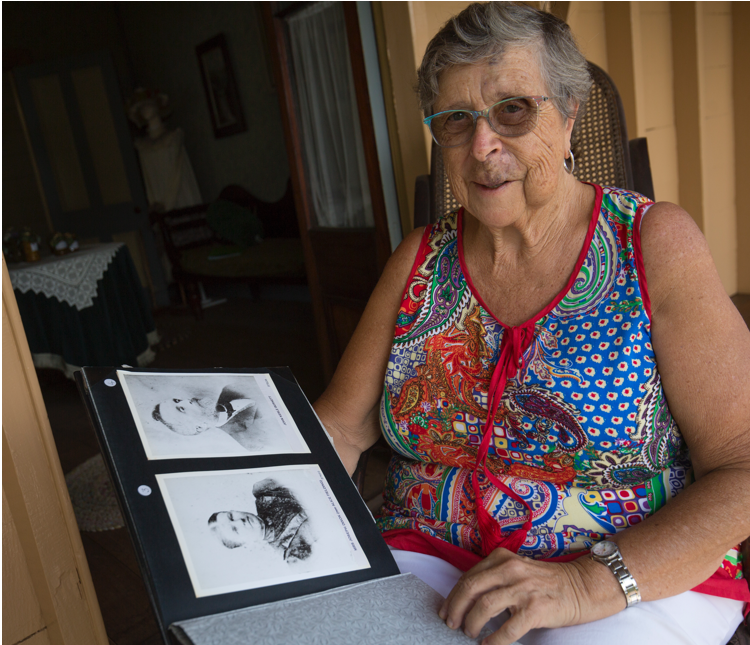 Prue with photographs of John and Ann Burnett, the original occupants of Pioneer Cottage, Buderim. 